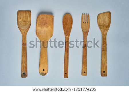 Empty wooden spoons and scoops on gray table. Top view.