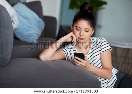 Young Asian woman using digital phone at home.