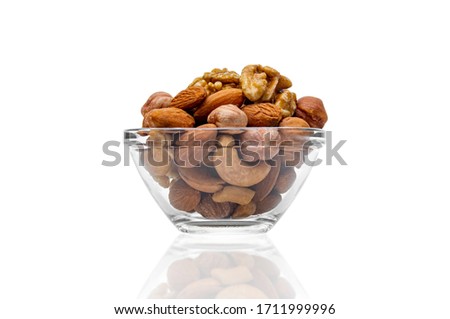 mix of nuts in a transparent plate front view, Assorted different nuts in a transparent plate on a white background