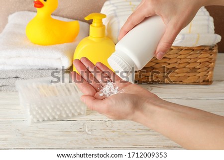 Mom applying talc powder from plastic tube. Baby hygiene Royalty-Free Stock Photo #1712009353