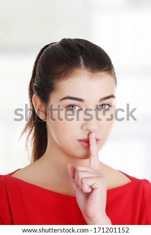 Attractive woman making a keep it quiet gesture