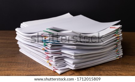 Stack overload document report paper with colorful paperclip place and copy space on black background, business concept footage paperless used Royalty-Free Stock Photo #1712015809