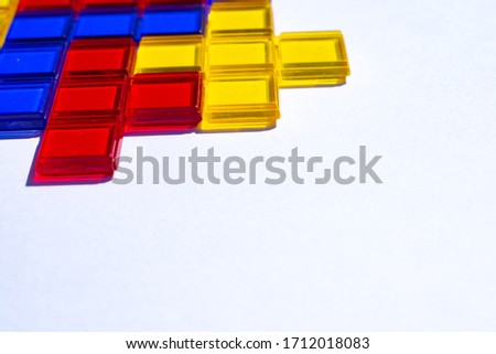 Colorful matching blocks on white background, high contrast colours, red blue yellow and green plastic transparent blocks matched to fit each other. educational blocks