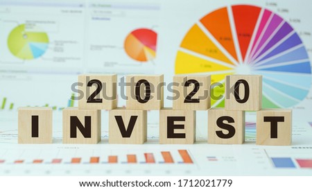 invest 2020 inscription on wooden blocks business concept graph and diagram background