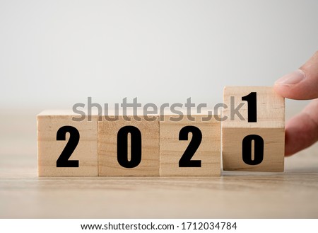 Hand flipping wooden blocks for change year  2020 to 2021 . New year and holiday concept. Royalty-Free Stock Photo #1712034784