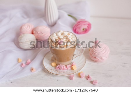 good morning card in pink. A Cup of coffee, a marshmallow and a pink flower on a light wooden background.