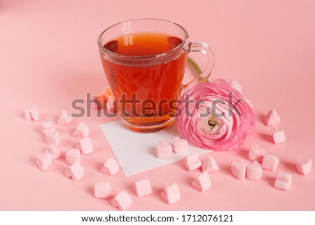 good morning card in pink. A Cup of tea, a marshmallow and a pink flower , an empty piece of paper, a note , space for text on a pink background.