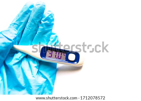 Hand in blue glove holding electronic thermometer showing high temperature in 37 degrees 
celsius
