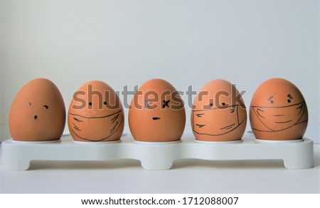 a group of five sad faced eggs in medical protective masks during pandemic virus illness