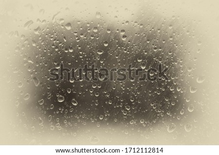 Drops of water on the misted glass. Toned photo, soft focus. Original vintage background with vignetting
