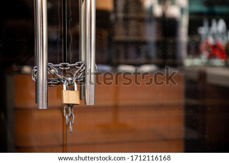 Closed Store due to Coronavirus pandemic. Locked Store Door with Padlock and Chains  Royalty-Free Stock Photo #1712116168