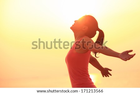 woman open arms under the sunrise at seaside wellness concept. Royalty-Free Stock Photo #171213566