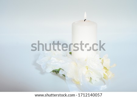 Romantic light of candle with white flowers.  Love and romance flowers and candle. Love with white flowers and candle. Wedding decor.  Beautiful white flowers and candle on white background. Love card