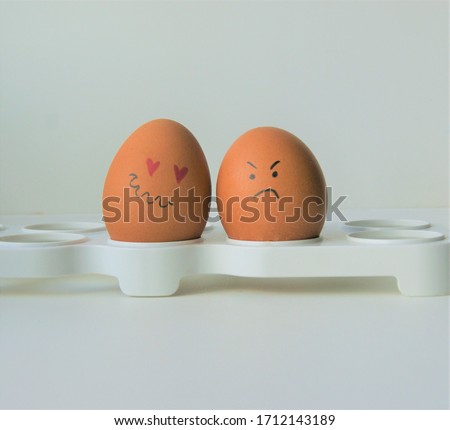 Two faced eggs, one is in love, another is sad and angry, different emotions. Saint Valentine day couple 
