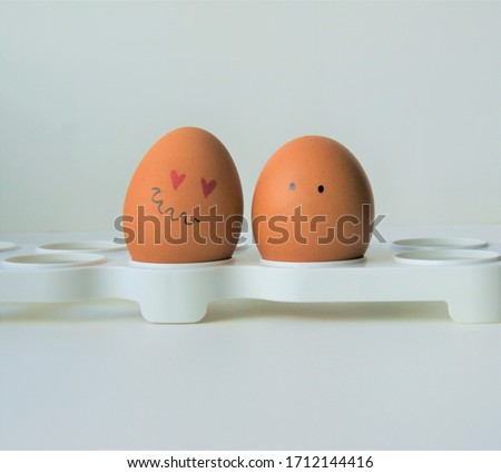 Two faced eggs, one is in love, another is silent. Saint Valentine day couple 