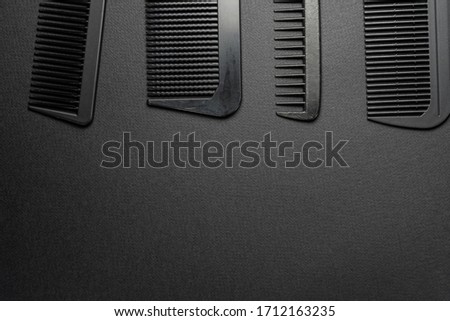 On a black surface are old barber tools. barber tools. four comb. black monochrome. frame. top view.