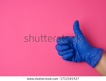 doctor in a white coat shows with his hand a gesture like, wearing blue latex medical gloves, close up