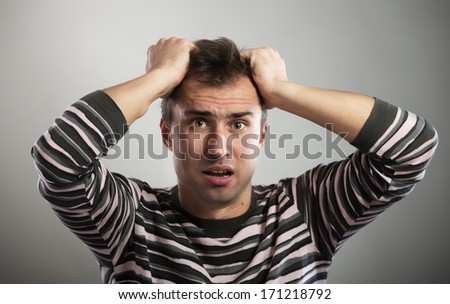 Portrait of a frustrated man looking at camera on gray background Royalty-Free Stock Photo #171218792
