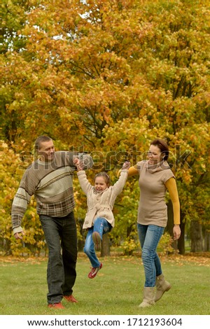 Portrait of happy smiling family relaxing in autumn park