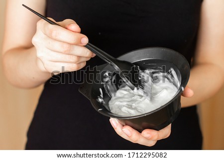 Tools for hair dyeing in woman hands. Colouring of hair at home Royalty-Free Stock Photo #1712295082