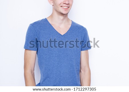  young slender guy with a creative hairstyle. an emotional portrait of a student in street clothes: summer shorts and a colored t-shirt. a shaven man with dyed hair