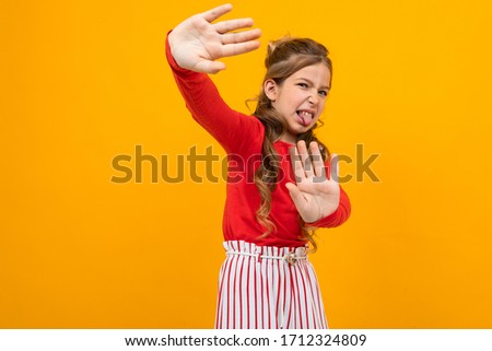 dissatisfied teenager girl waving hands on a yellow background with copy space