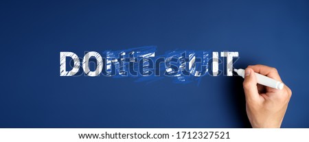 a man’s hand crossed out the words don't quit and wrote the phrase do it on a blue background. decision making concept in difficult situations Royalty-Free Stock Photo #1712327521