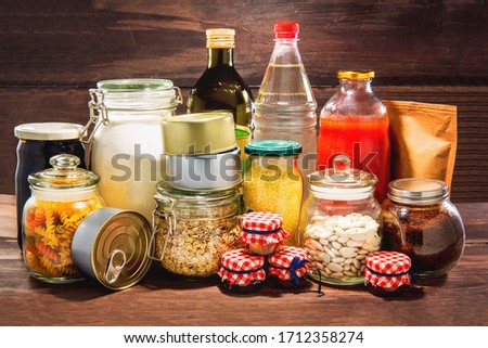 Emergency stockpiling of various food, on top of wooden background. Royalty-Free Stock Photo #1712358274
