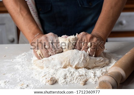 hands kneading flour, yeast eggs bakery ingredients milk honey in home kitchen Royalty-Free Stock Photo #1712360977
