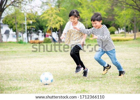 Kids playing soccer in the park Royalty-Free Stock Photo #1712366110