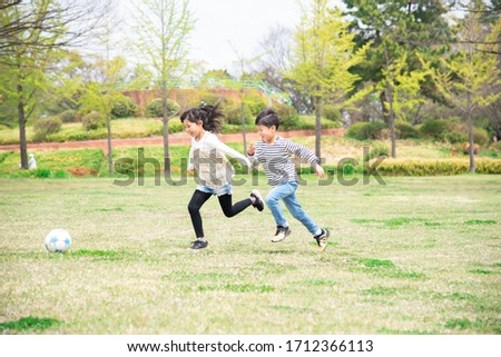 Kids playing soccer in the park Royalty-Free Stock Photo #1712366113