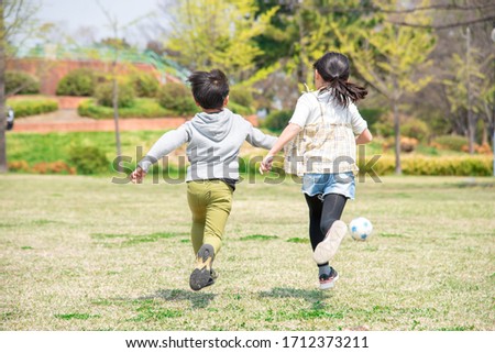 Kids playing soccer in the park Royalty-Free Stock Photo #1712373211
