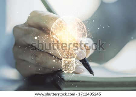 Creative idea concept with light bulb illustration and hand writing in notebook on background. Multiexposure