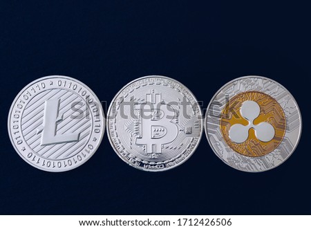 Bitcoin, litecoin and ripple coins currency finance money on graph chart background. Bitcoin as most important cryptocurrency concept. Stack of cryptocurrencies with a golden bitcoin in the middle.