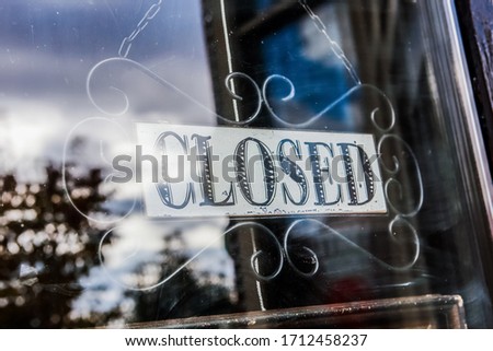 Closed sign on a business,  image shot through dirty glass door
