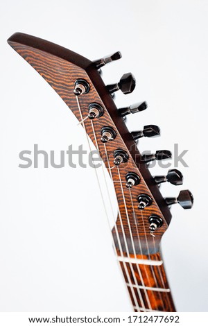 Seven-string electric guitar made of dark wood. Shot on a white background. Background for music and creativity.