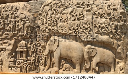 Descent of the Ganges: A giant open-air rock bas relief carved on two monolithic rocks in Mahabalipuram. It contains sculptures of animals, God, people and half-humans carved in the rock relief. Royalty-Free Stock Photo #1712488447