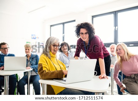 Group of senior people attending computer and technology education class. Royalty-Free Stock Photo #1712511574