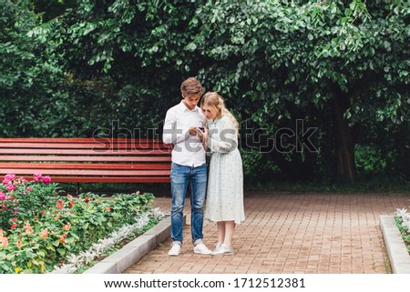 A girl and a man take pictures of themselves on the phone, gadgets, selfies, photographing on the phone's camera, a memory picture, laughter, joy, love