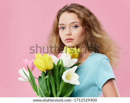 Nice girl with a bouquet of flowers looking at the camera