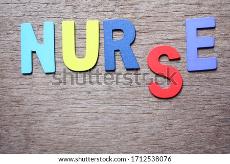 The inscription "NURSE" of the wooden letters on brown wood background.
