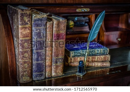 old books on desk and pen writing