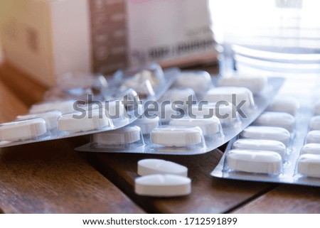 pills and glass of water on wooden table