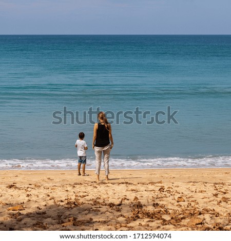 girl with a boy stand on the sandy seashore 