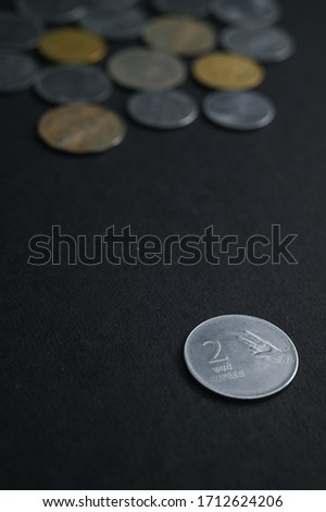 Indian Currencies of One Rupee,Two Rupee and Five Rupee Coins were laid out with Black background with Negative spacing. Indian Currency for Banking, Savings, Finance, Money Crisis, Financial Crisis