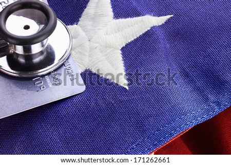 Stethoscope placed over American flag and credit card. 
