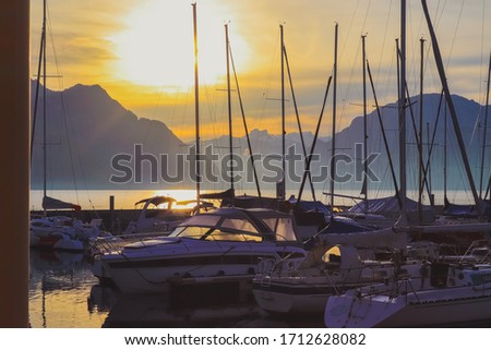 Picture of boats in the early morning sun with mountain scenery