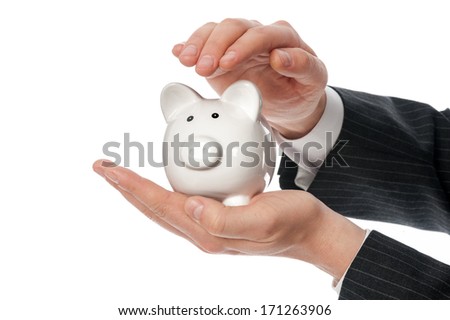 Protect your money concept. Two man's hands covering small white piggy bank isolated on white background.