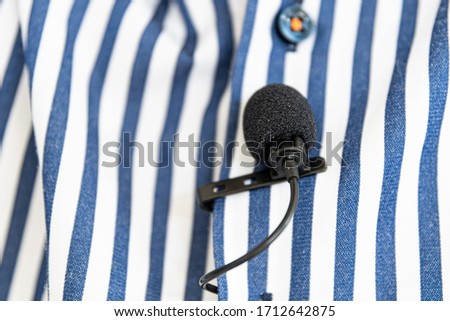 Black Clip-On Microphone on a blue striped shirt