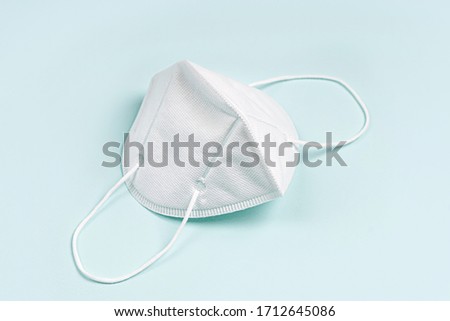 White medical mask on blue background.  Face mask protection, KN95 or N95 respirator for protection virus, flu, coronavirus, COVID-19. Medical equipment.  Royalty-Free Stock Photo #1712645086